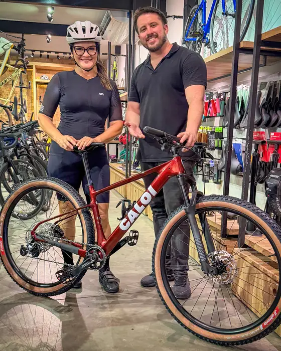 Cliente retirando uma Caloi vermelha na loja Vow Bikes